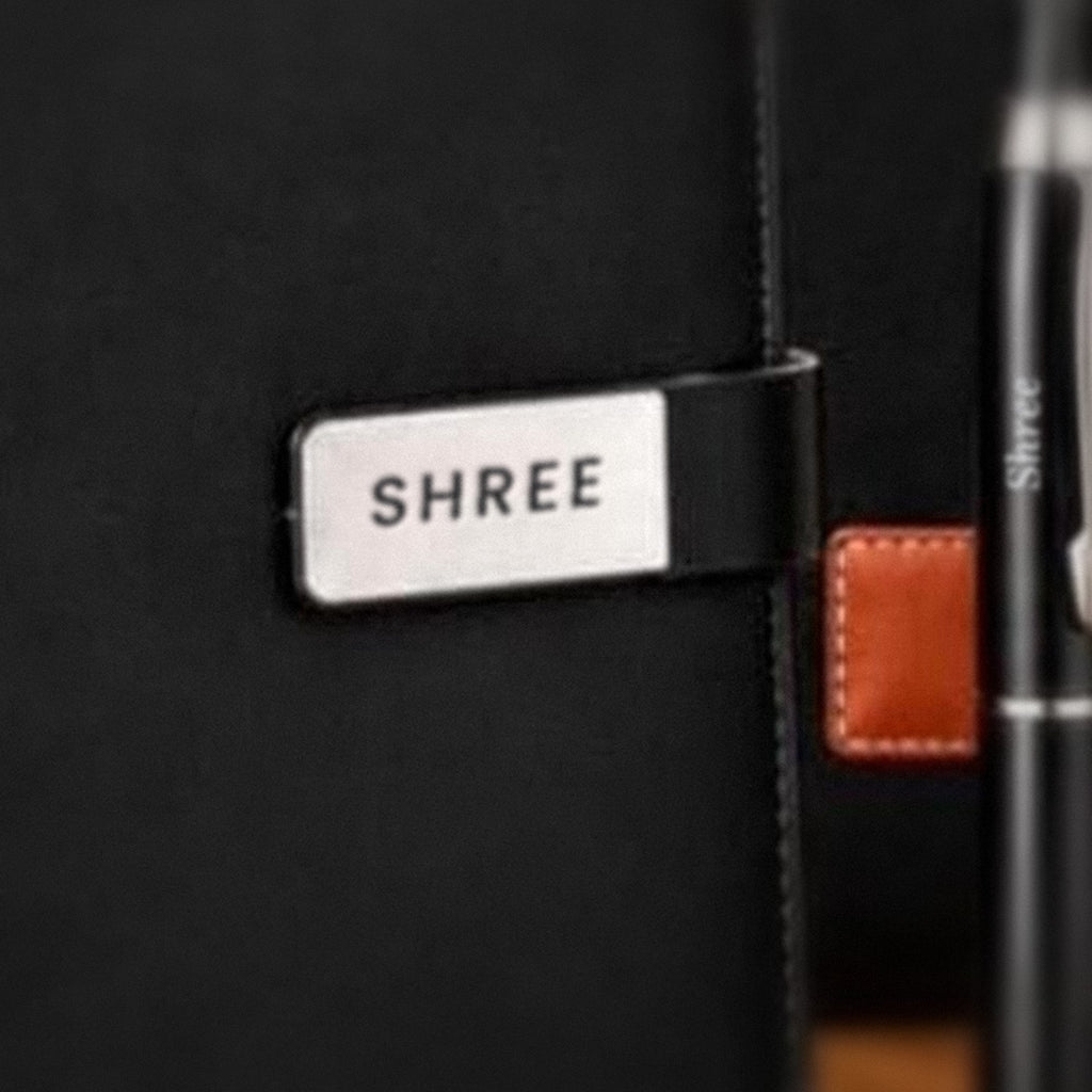 Close-up of a name engraved in black on the metal plate of an executive diary