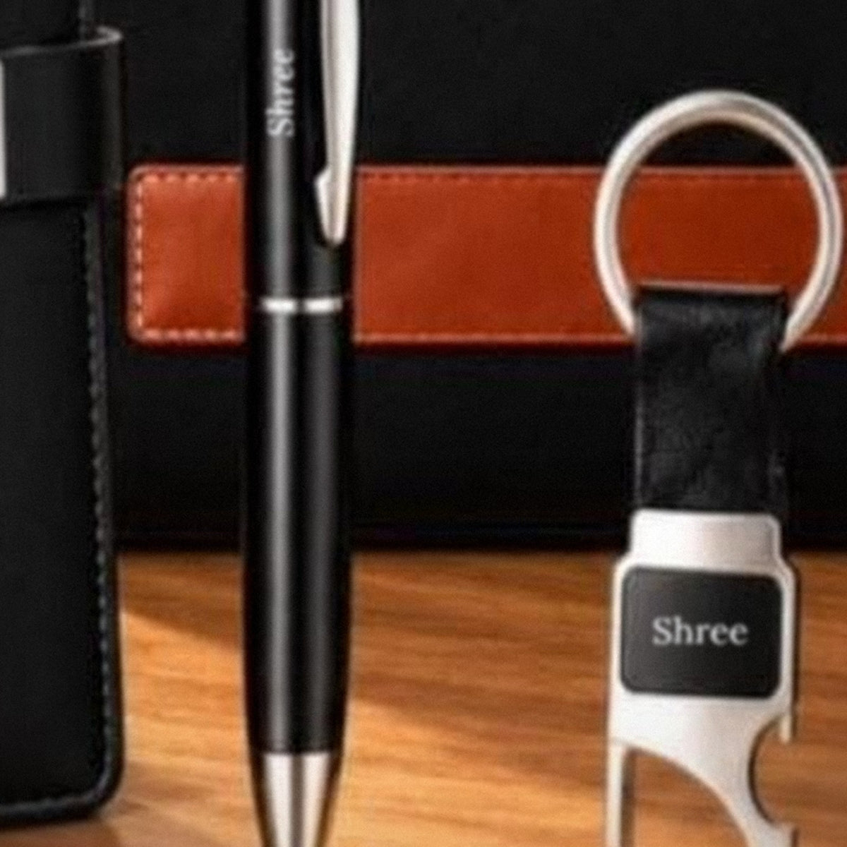 Black metal pen and keychain, each engraved with a name in white